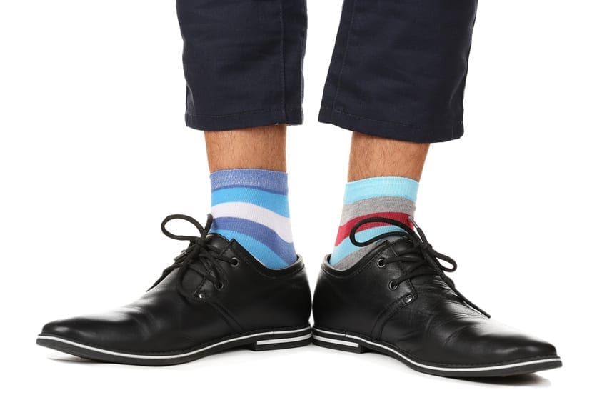 Man leg in suit and colorful socks, isolated on white