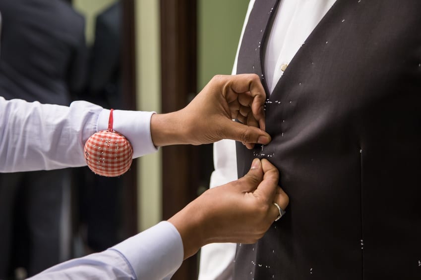 A local men's tailor measuring a custom suit