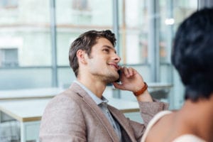 Man dressed in business casual clothing talking on phone