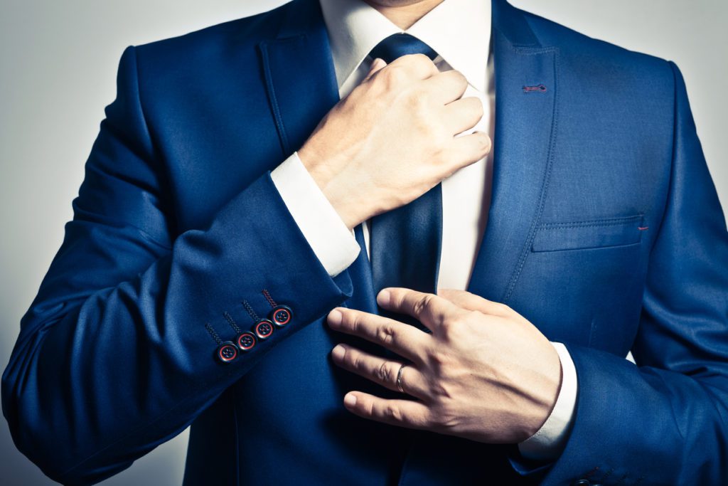 businessman-in-blue-suit-adjusting-his-tie-preparing-for-client-meetings