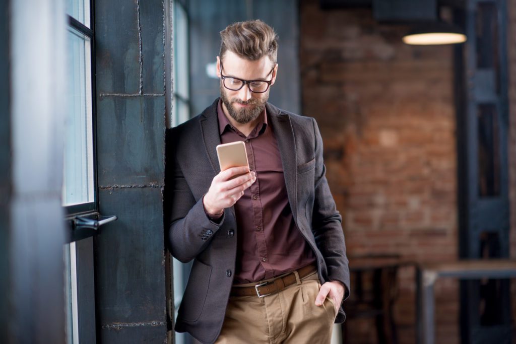 businessman-using-a-smartphone-in-a-studio-office-wardrobe-concept