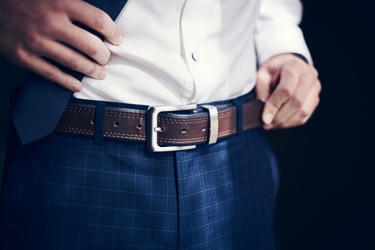 Groom wearing a men's belt with his jeans and shirt on his wedding day.