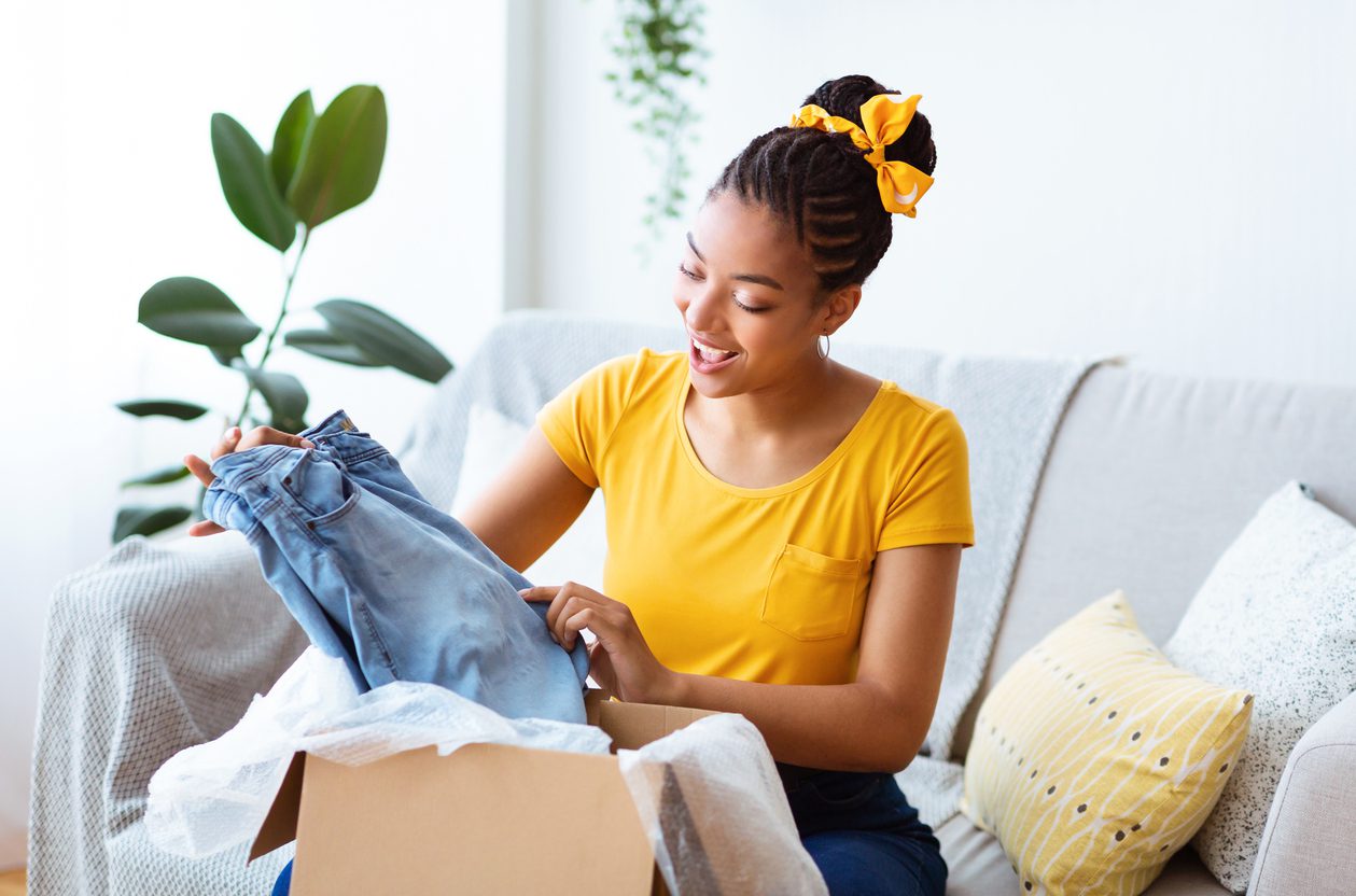 Woman unboxing the perfect clothing gift at home.