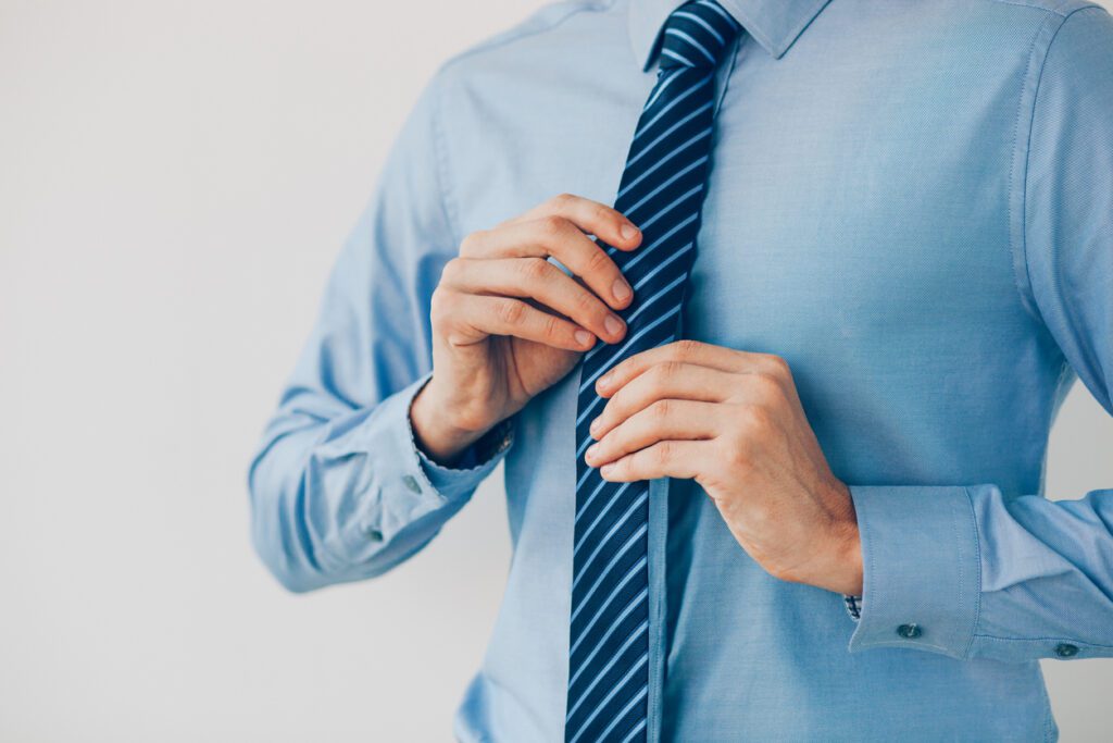 Man holding his beloved tie preparing for his meeting.