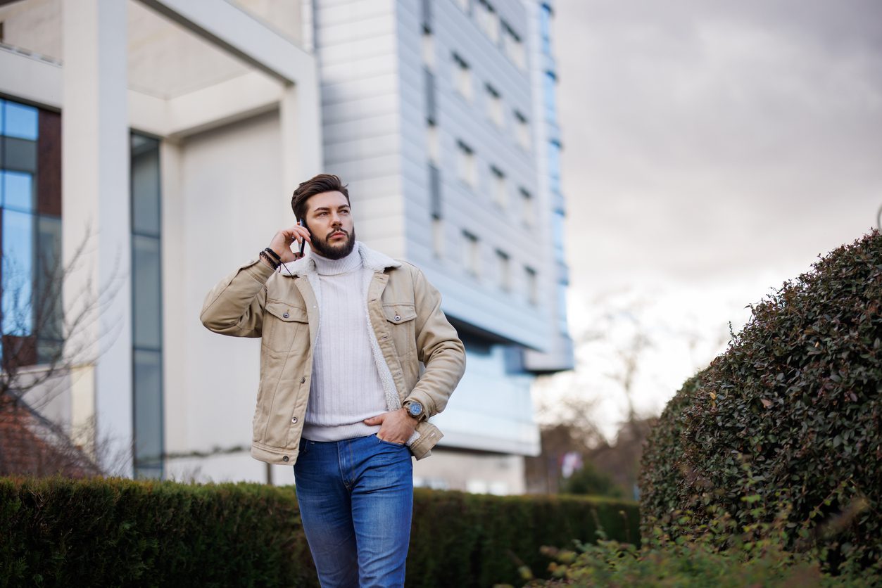 Man wearing stylish shacket while talking on the phone in the city.