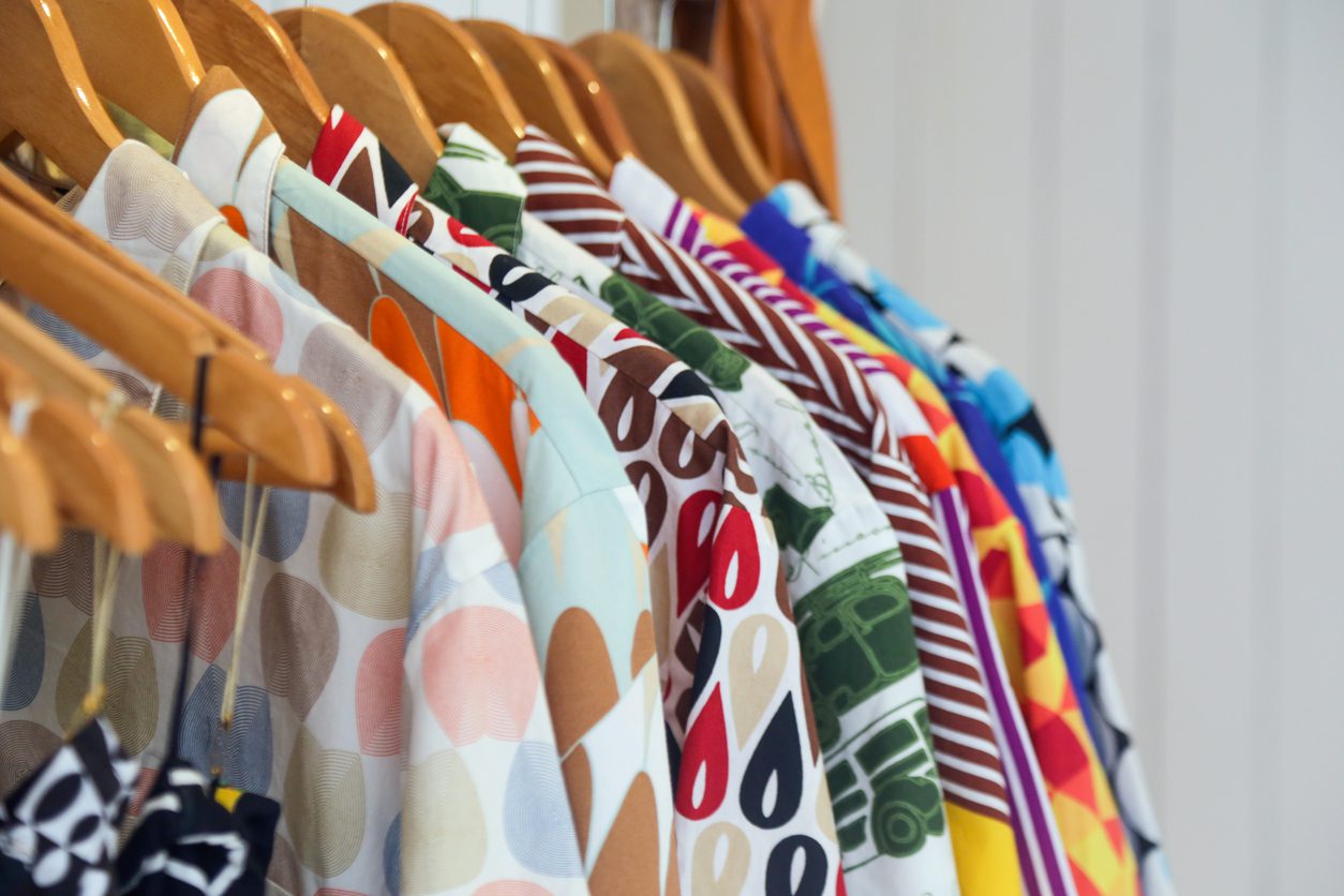 Colorful shirts hanging on wooden hangers to suggest wardrobe this spring.